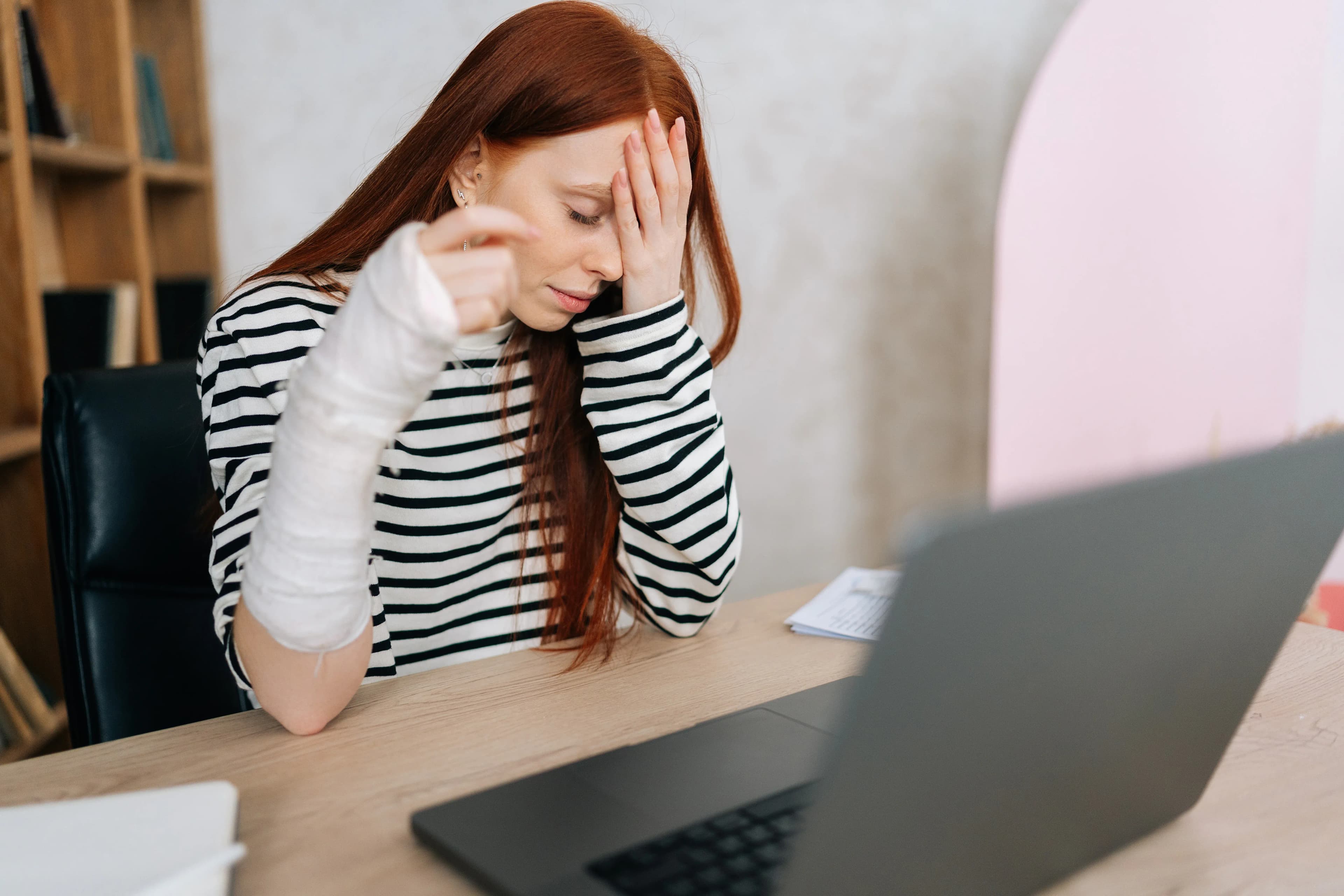vrouw freelancer met gebroken arm