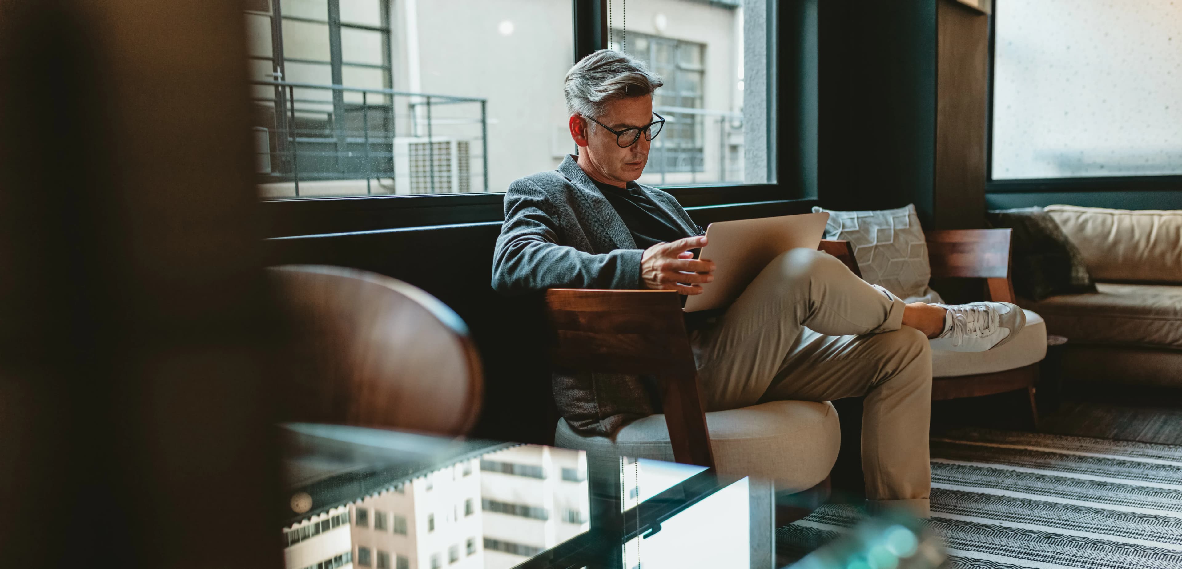 man op bank met laptop
